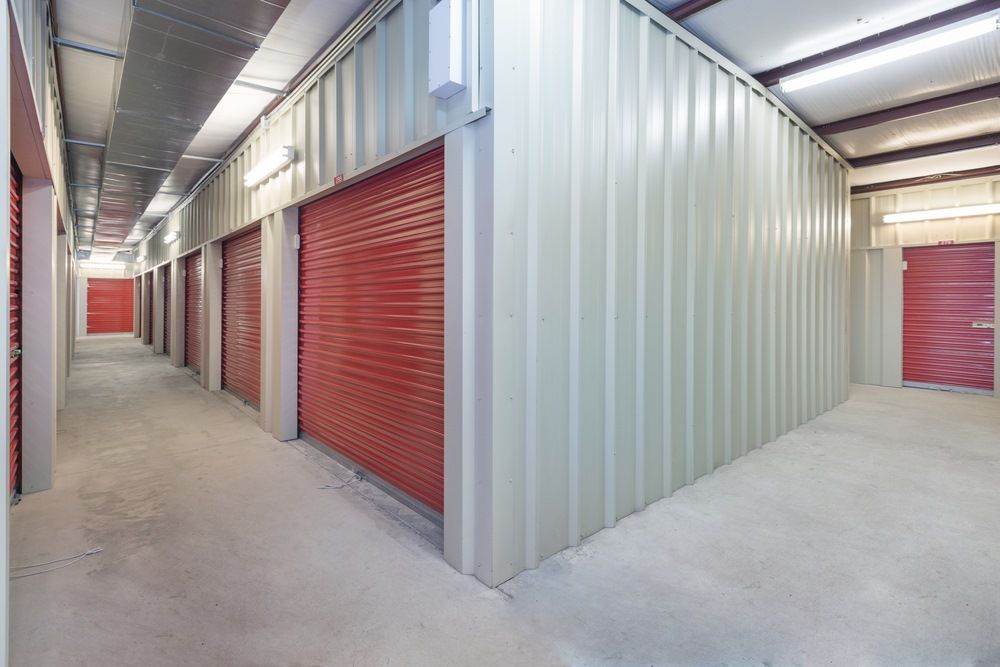A Long Hallway in a Storage Facility With Red Doors — North Coast Storage in North Boambee Valley, NSW