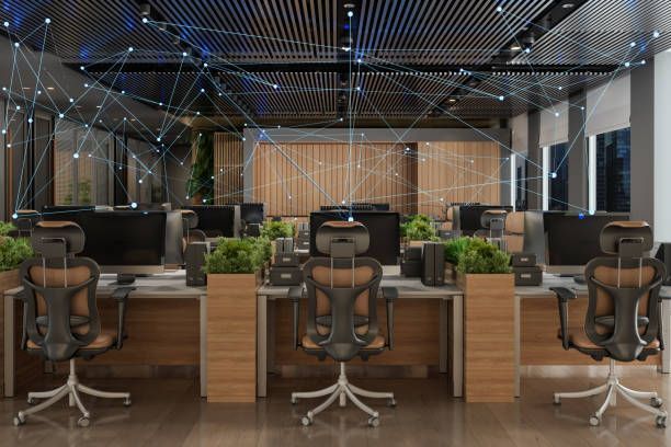 A modern office workspace with rows of desks and ergonomic chairs, overlaid with a digital network graphic on the ceiling.