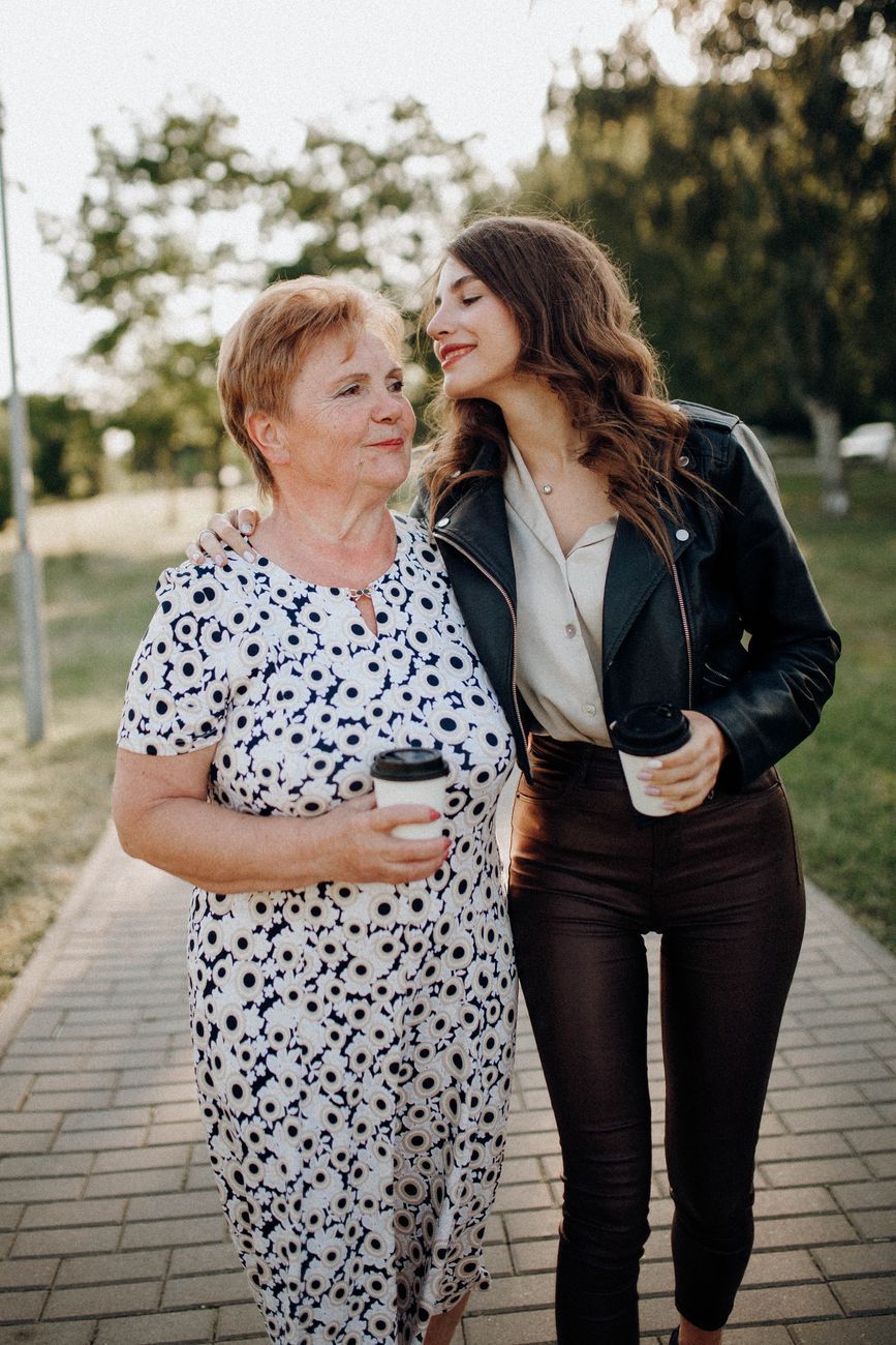Adult daughter walking arm in arm with her mother