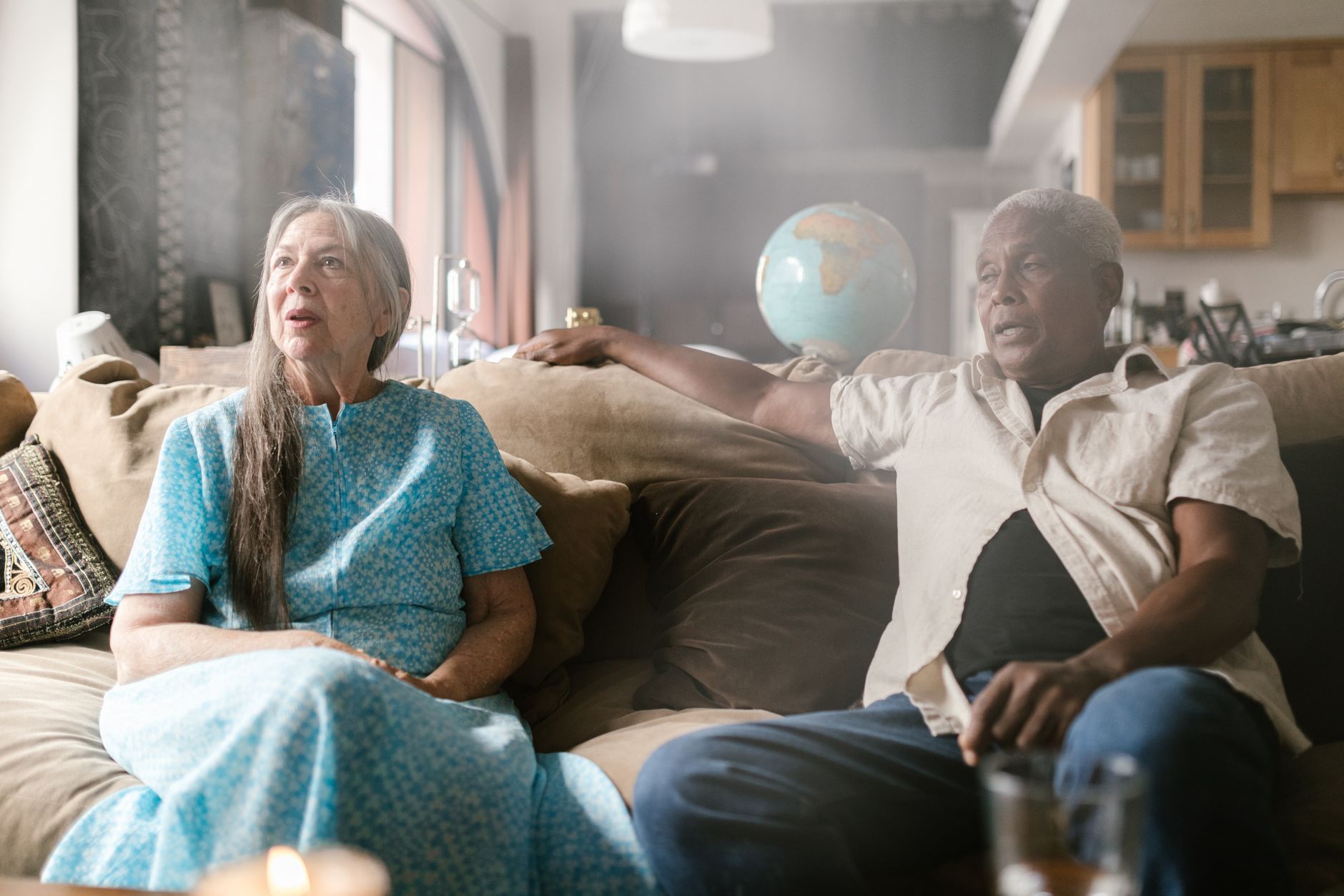 Older couple sitting together on the sofa talking in their living room