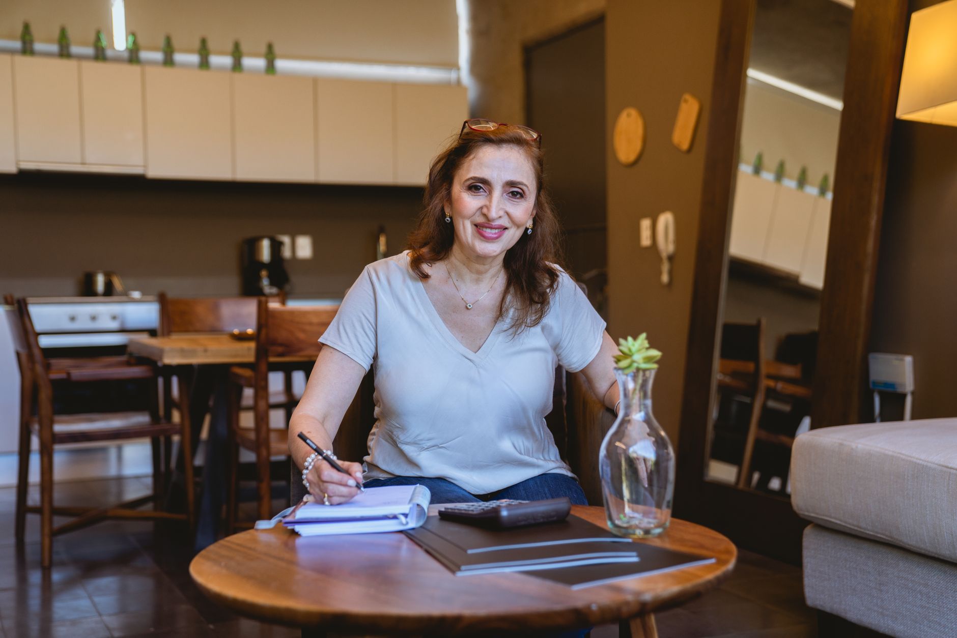 Woman writing a moving plan in a notebook at her dining table