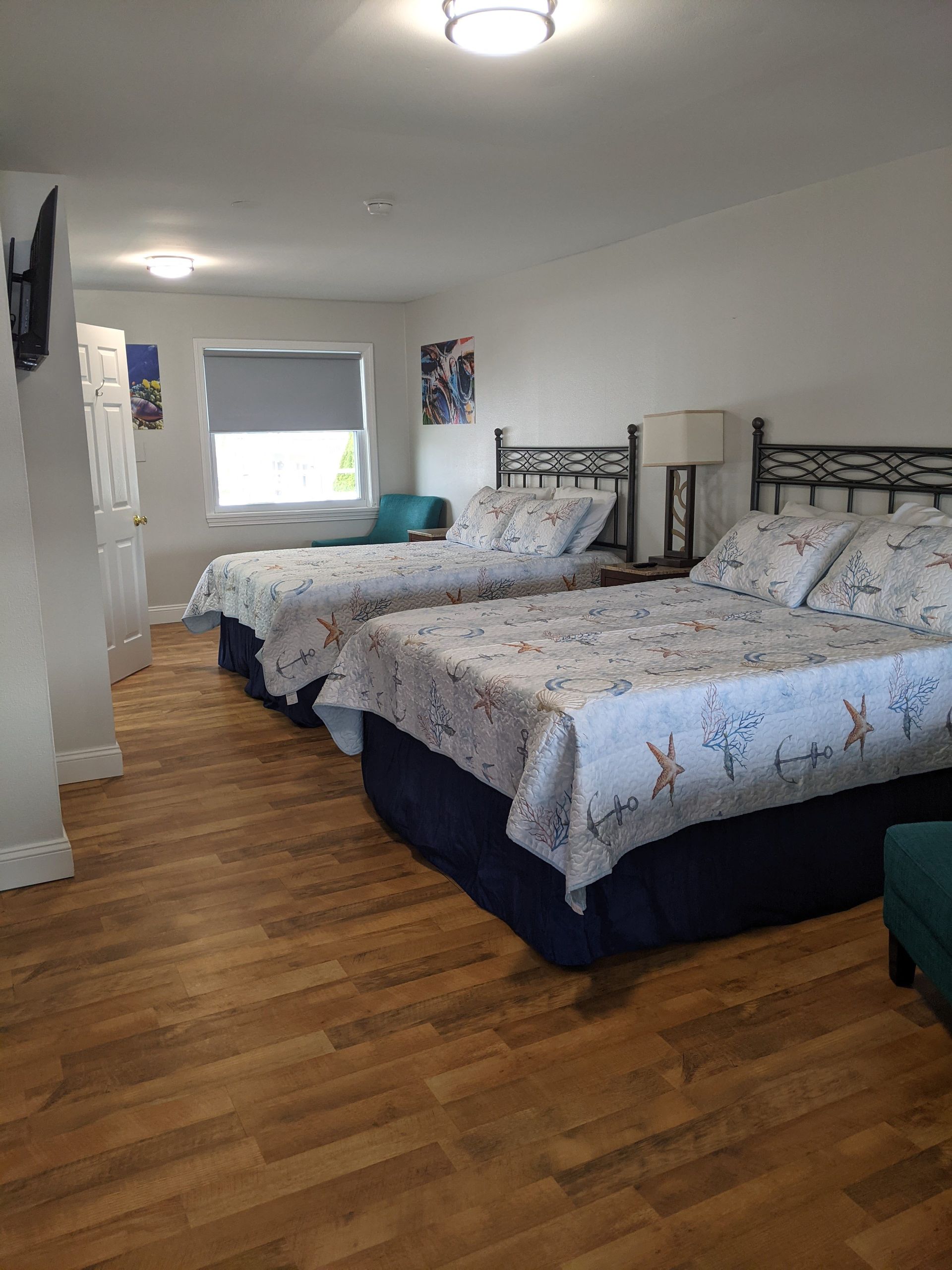A hotel room with two beds and a chair.