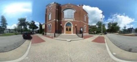 A 360 degree view of Trinity Wesleyan Methodist church with a car parked in front of it.