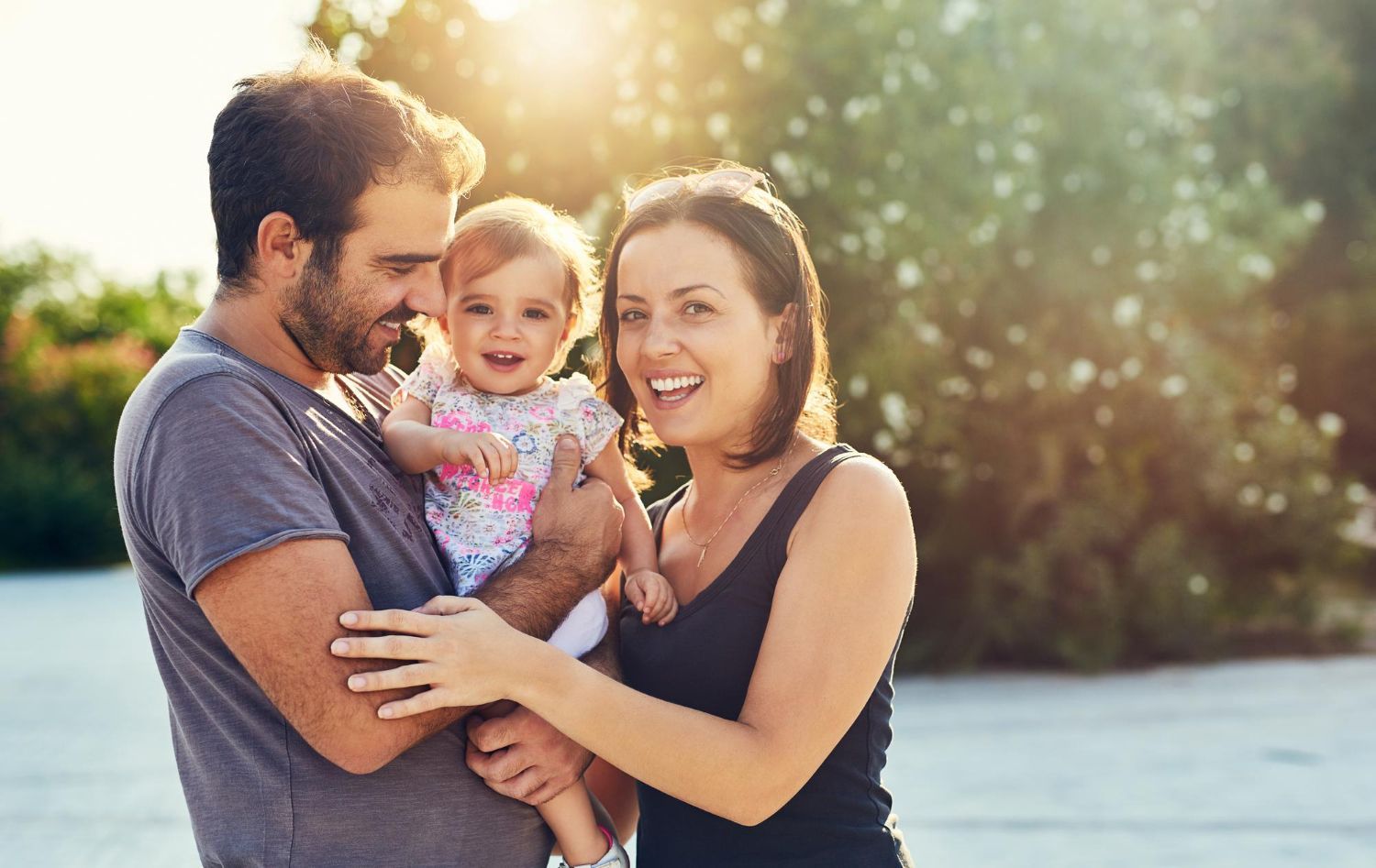 A man and woman are holding a baby in their arms. 