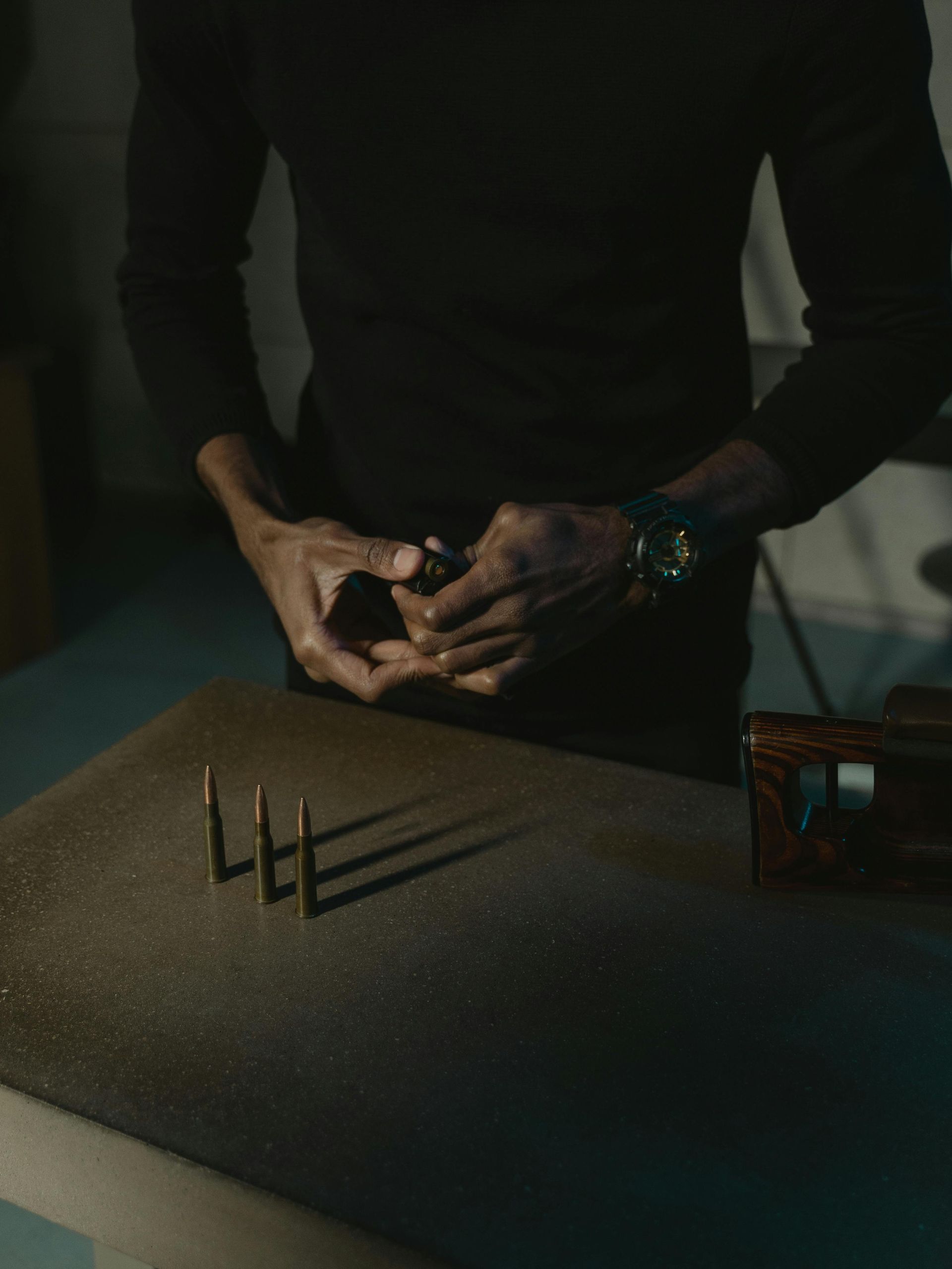 man loading bullets into a magazine