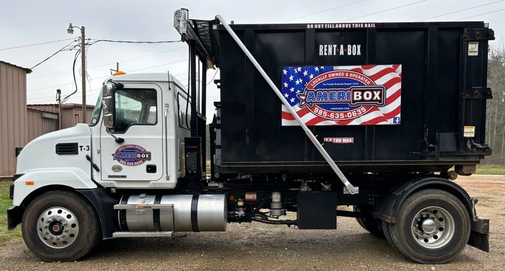 A picture of an Ameribox truck hauling a dumpster on the back of it in Mandeville, LA.