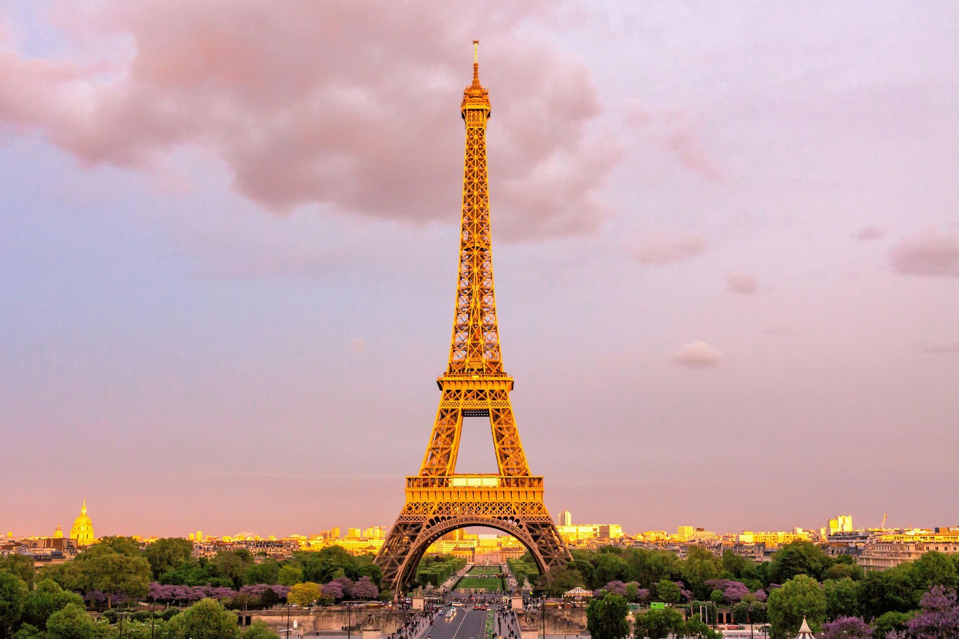 Eiffeltårnet er oplyst ved solnedgang i paris