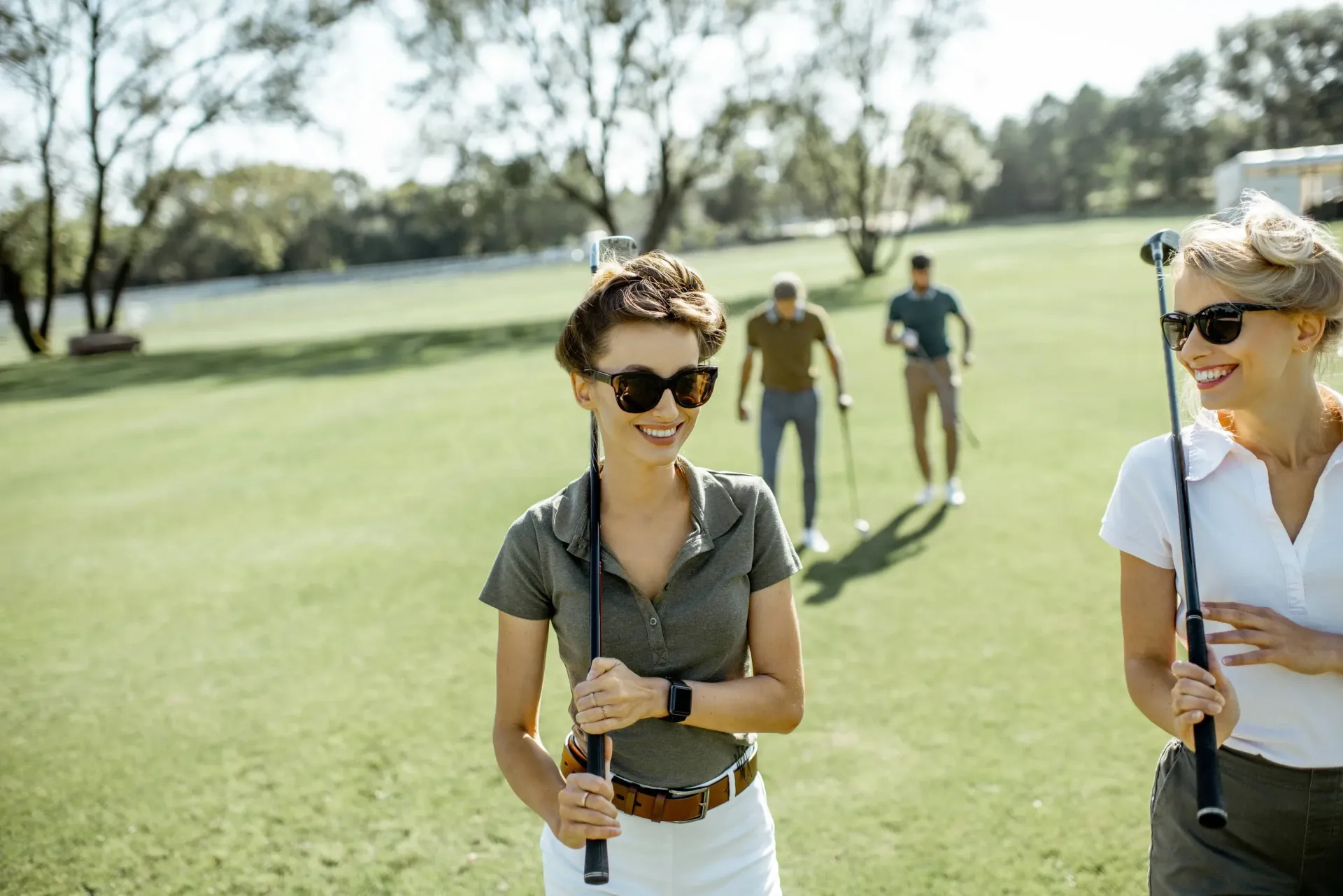 Friends playing golf on a sunny day at the course.