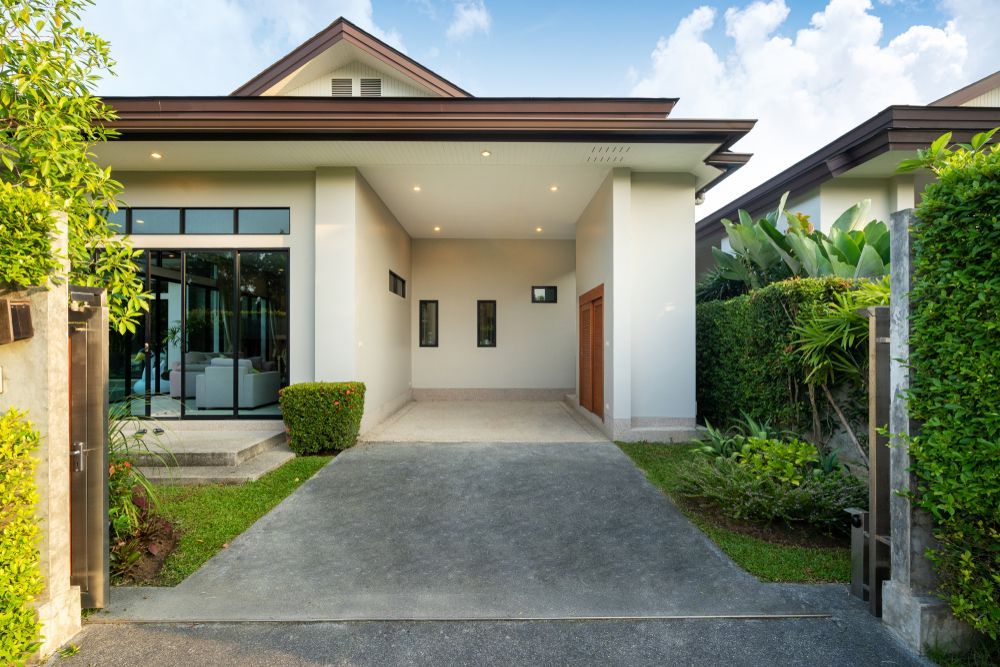 Modern House With Driveway, Carport, and Lush Landscaping — Atherton Tableland Concreting in Yungaburra, QLD