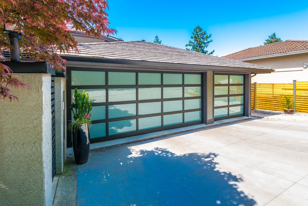 Garage With Glass Panels, Silver Frames, and Concrete Driveway — Atherton Tableland Concreting in Yungaburra, QLD