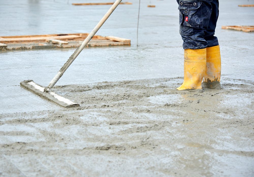 Person in Yellow Boots Smoothing Wet Concrete — Atherton Tableland Concreting in Wongabel, QLD
