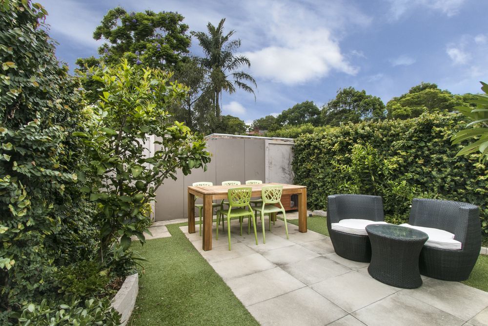 Outdoor Patio With Dining Table, Green Chairs, and Seating Area — Atherton Tableland Concreting in Yungaburra, QLD