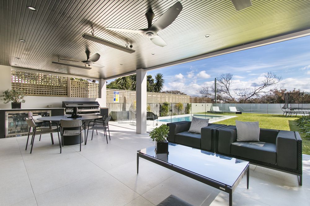Covered Outdoor Patio With Pool View, Seating, and Grill — Atherton Tableland Concreting in Yungaburra, QLD