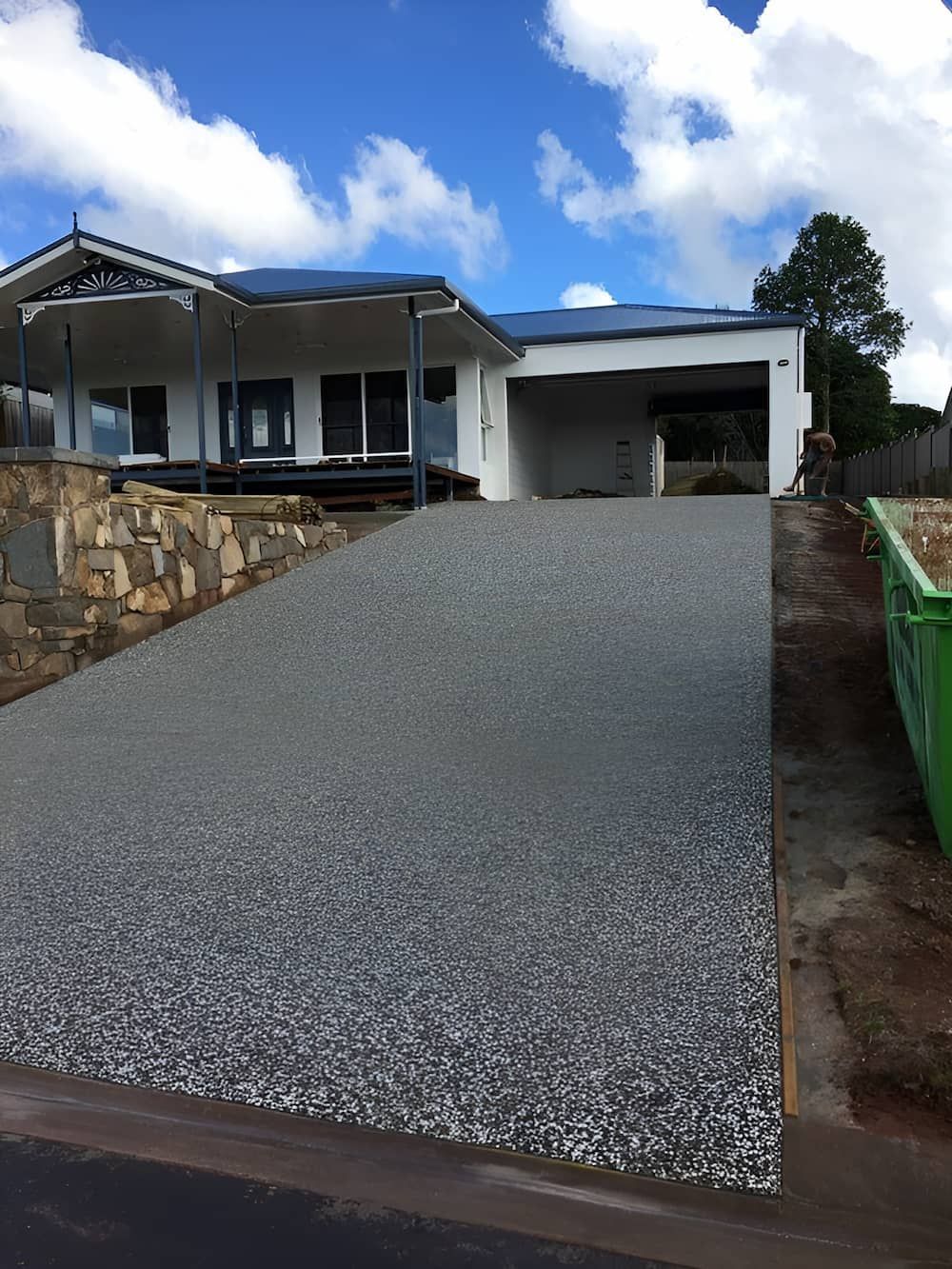 Driveway leading up to a white house with a garage on a sunny day — Atherton Tableland Concreting in Yungaburra, QLD