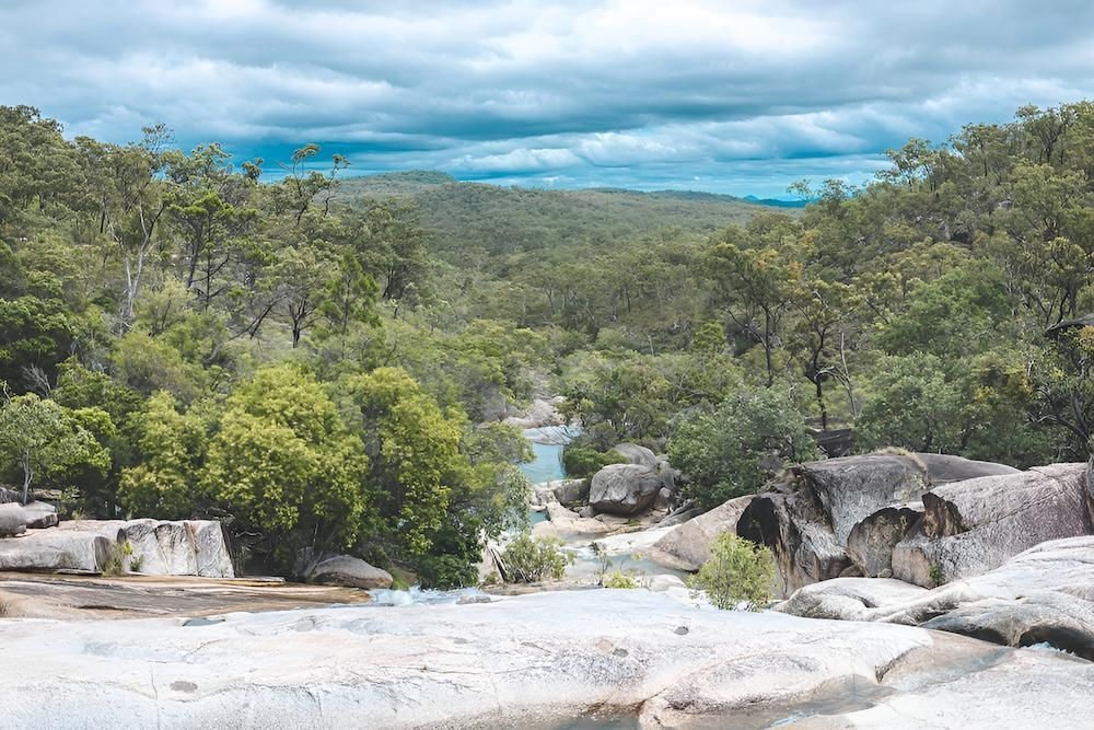 A River Runs Through a Lush Green Forest Surrounded by Rocks and Trees — Atherton Tableland Concreting in Mareeba, QLD