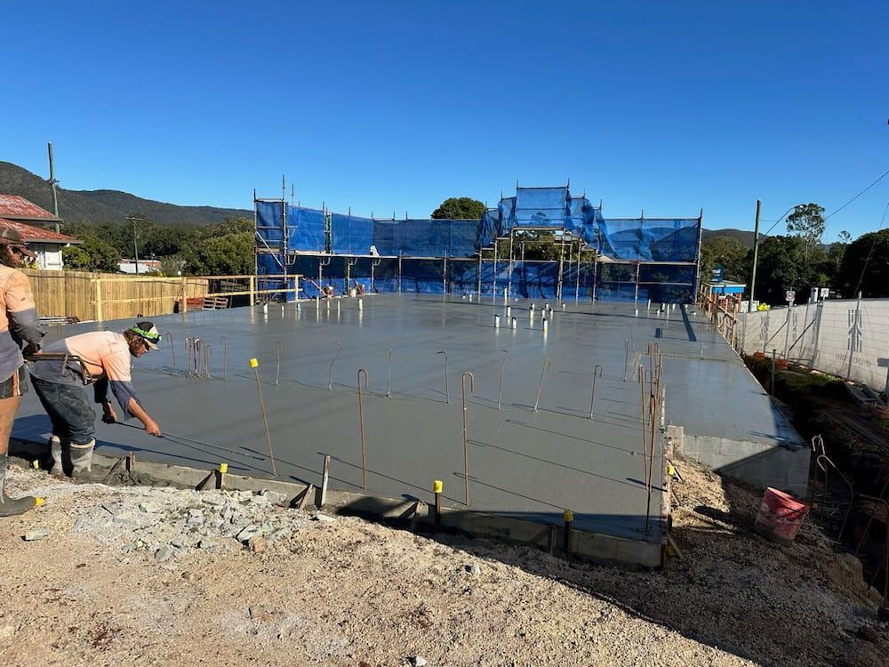 A Group of Construction Workers Are Working on a Concrete Floor — Atherton Tableland Concreting in Yungaburra, QLD