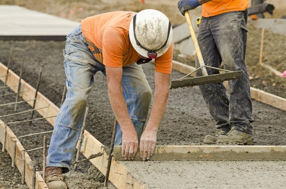 Two Construction Workers Are Working on a Concrete Sidewalk — Atherton Tableland Concreting in Tablelands, QLD