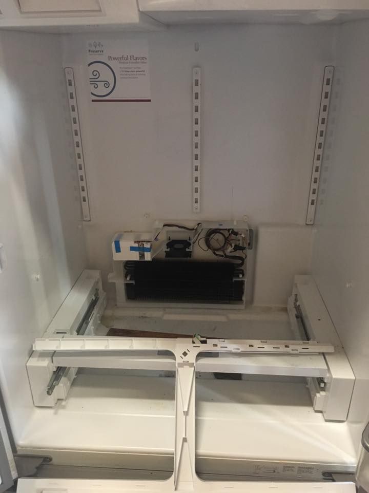 The inside of an empty refrigerator with the door open.