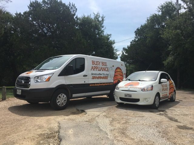 Two busy bee appliance vans are parked next to each other