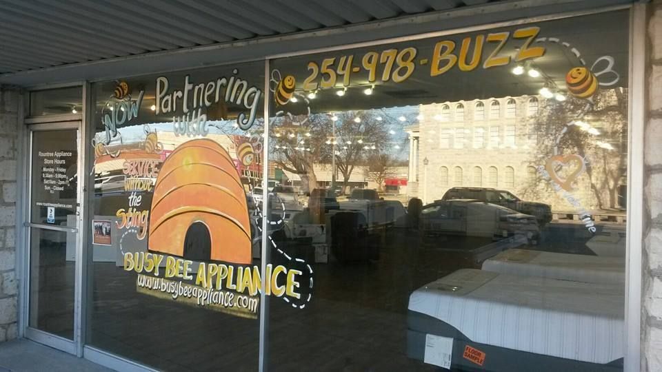 A store front with a bee on it that says buzz