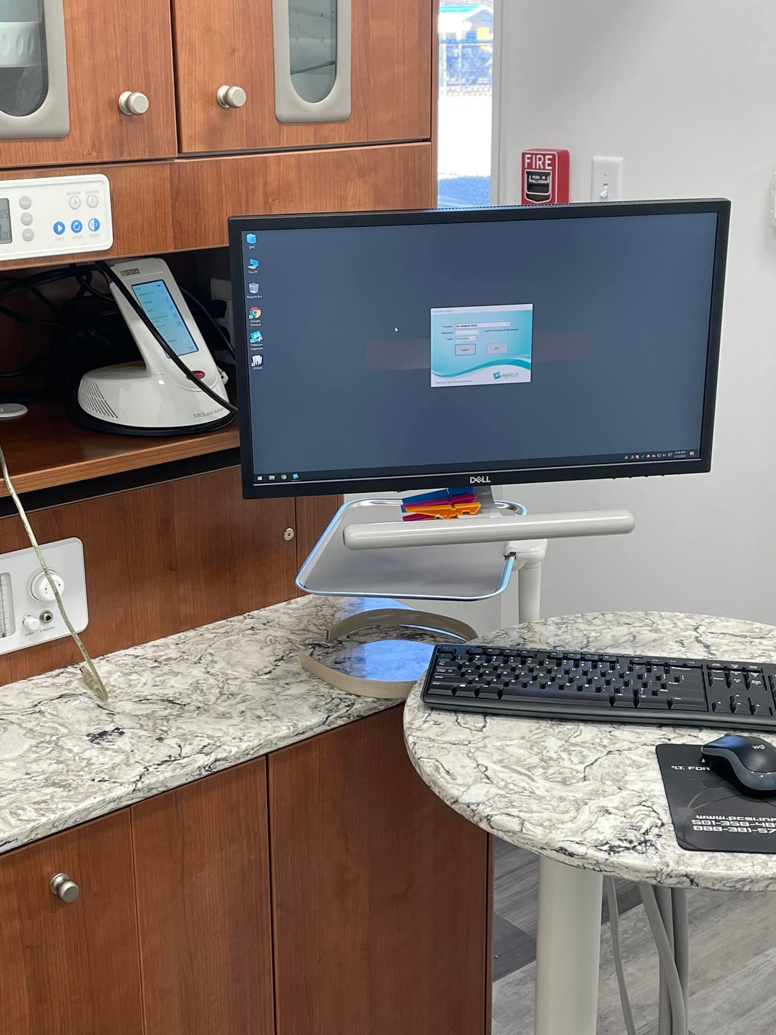 A computer monitor is sitting on a table next to a keyboard.