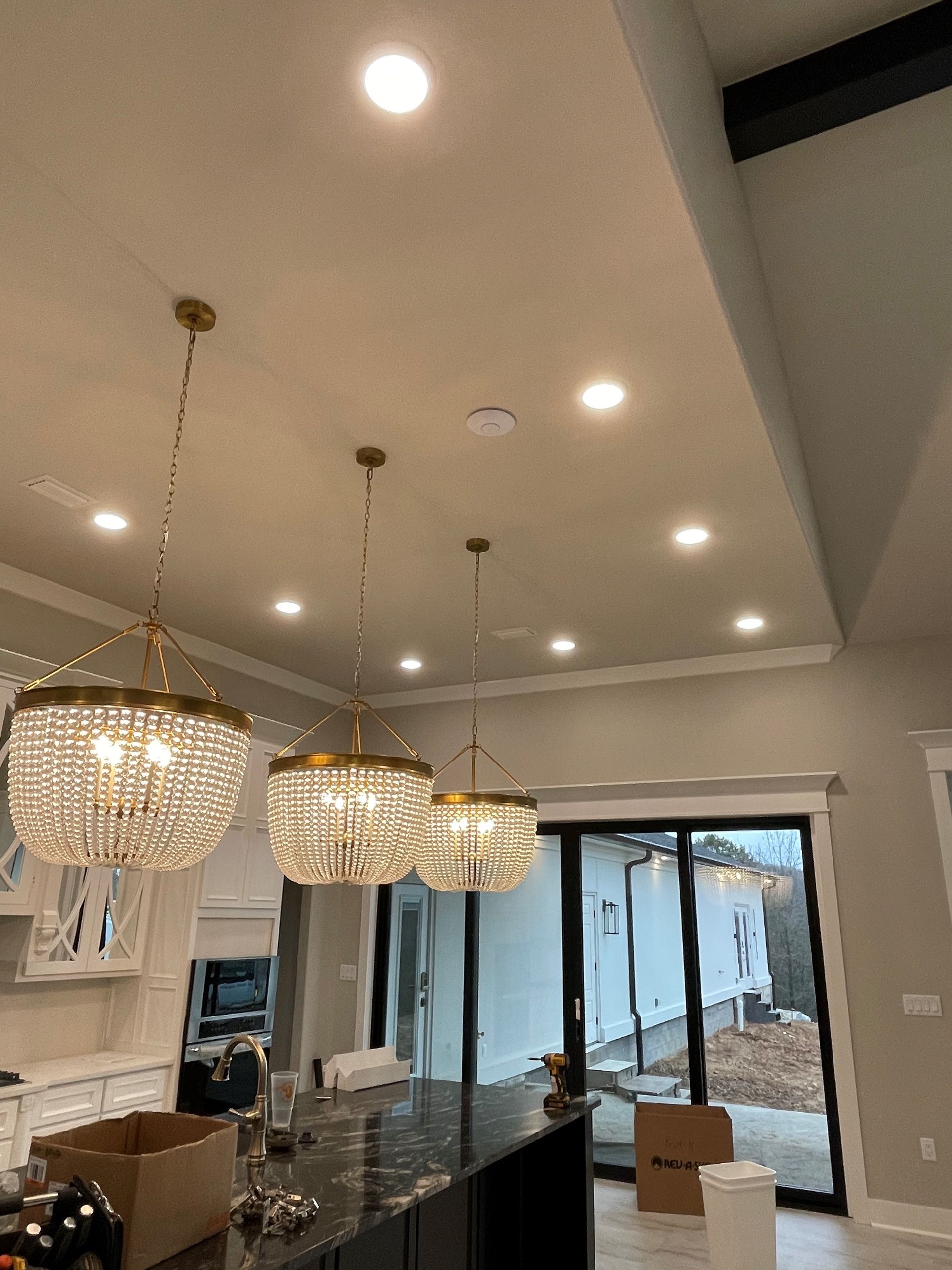 A kitchen with a lot of lights hanging from the ceiling.