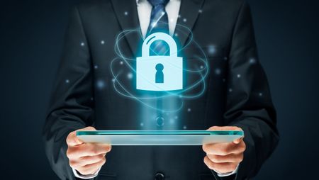 A man in a suit is holding a tablet with a padlock coming out of it.