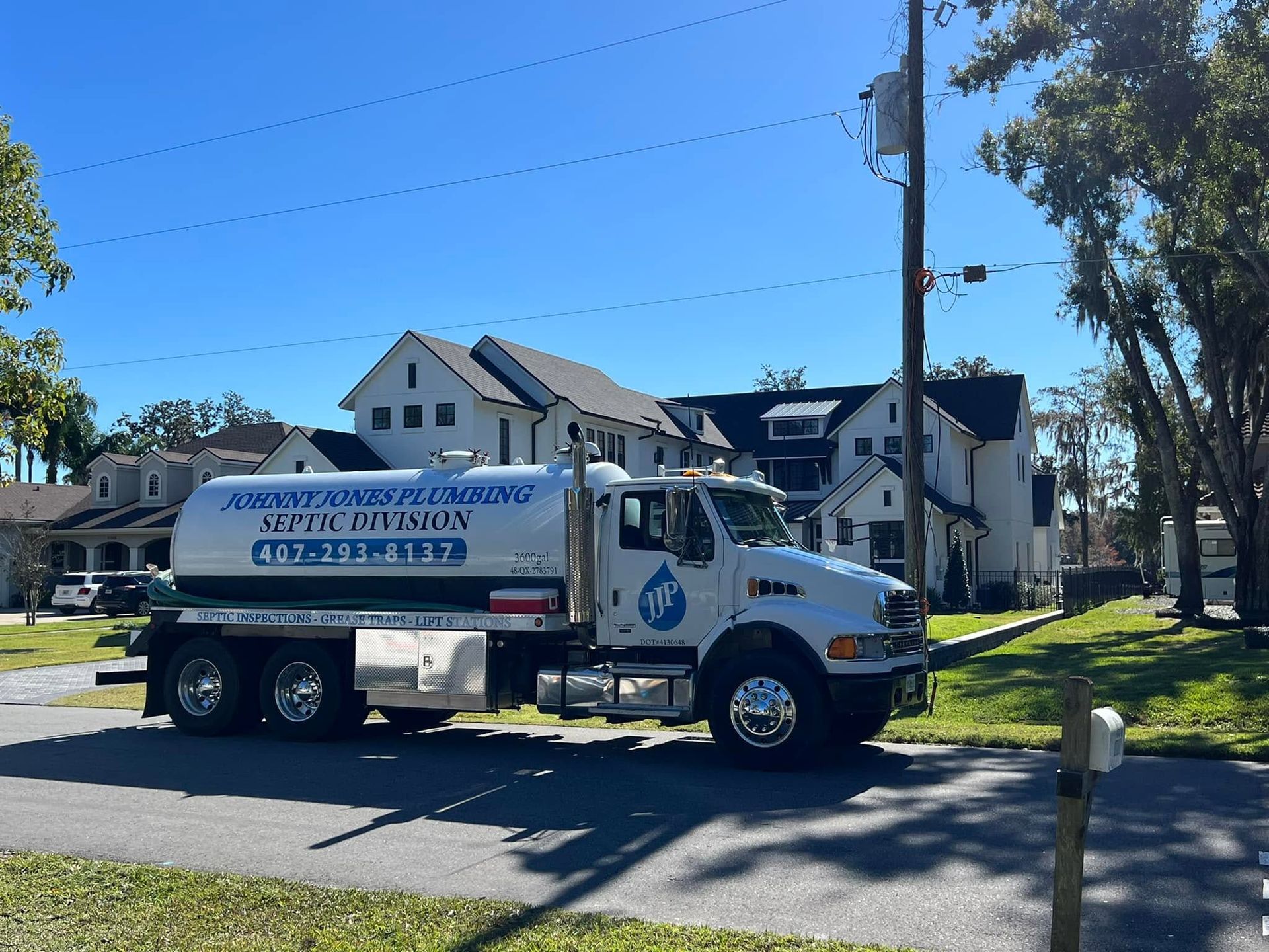 Johnny Jones Plumbing - A white truck with a blue sticker on the side that says ' water cleaning '