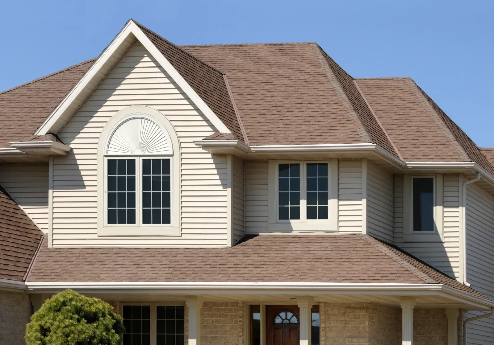 A house with a brown roof and white siding