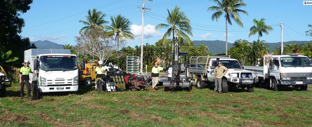 A Group of Trucks Are Parked in a Grassy Field — Advanced Vegetation Management in Stratford, QLD