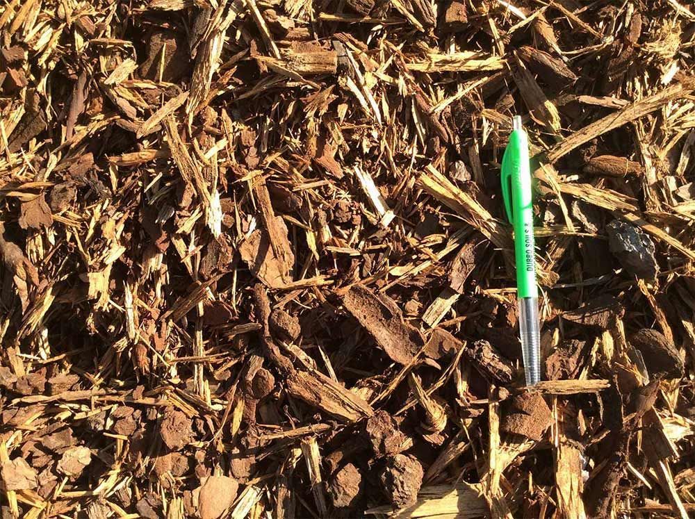 Green Pen Laying on Mulch — Dubbo Soils & Landscaping Supplies in Dubbo, NSW