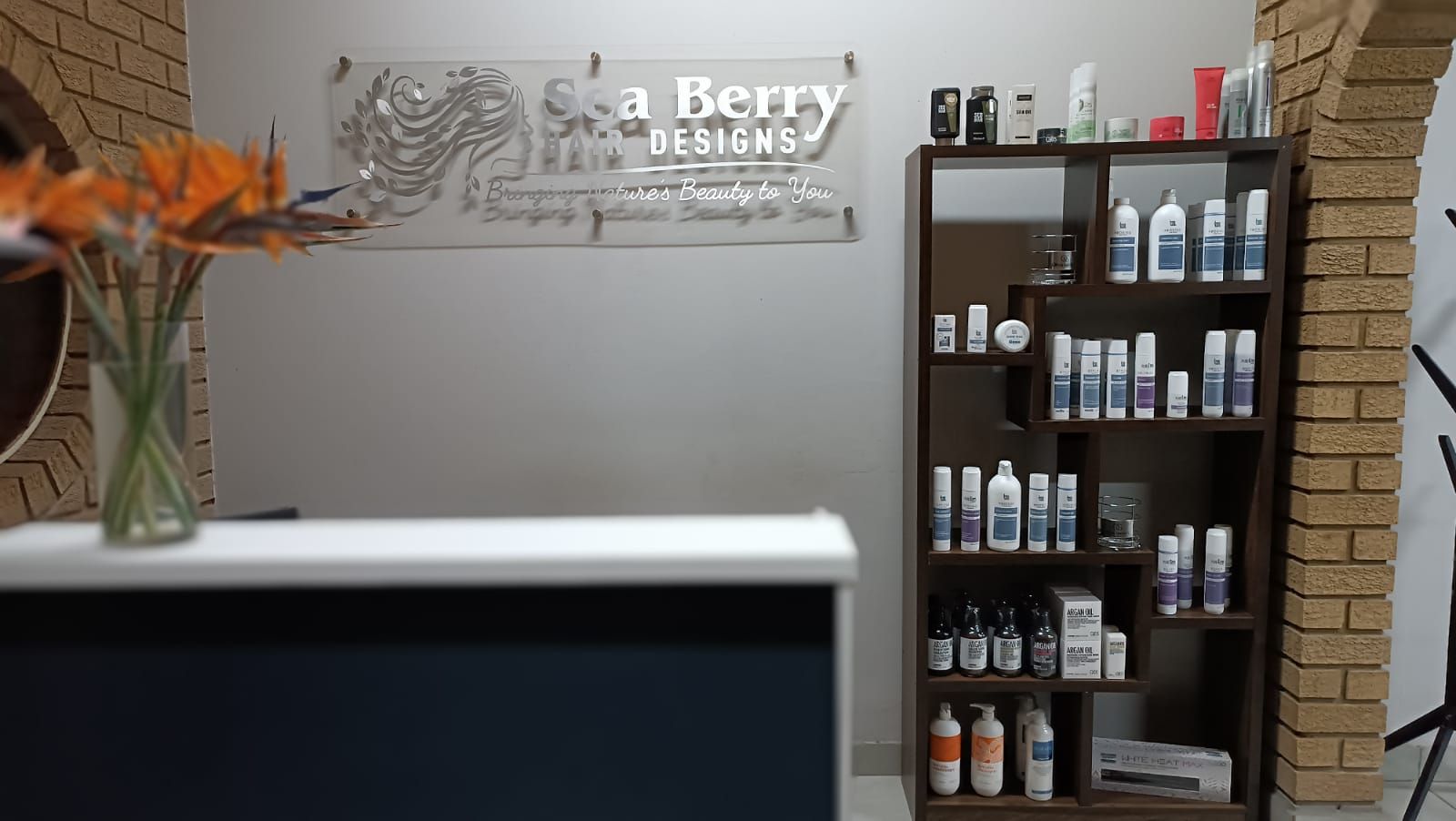 Sea Berry Hair Designs salon interior with warm amber lighting and autumn-toned decor