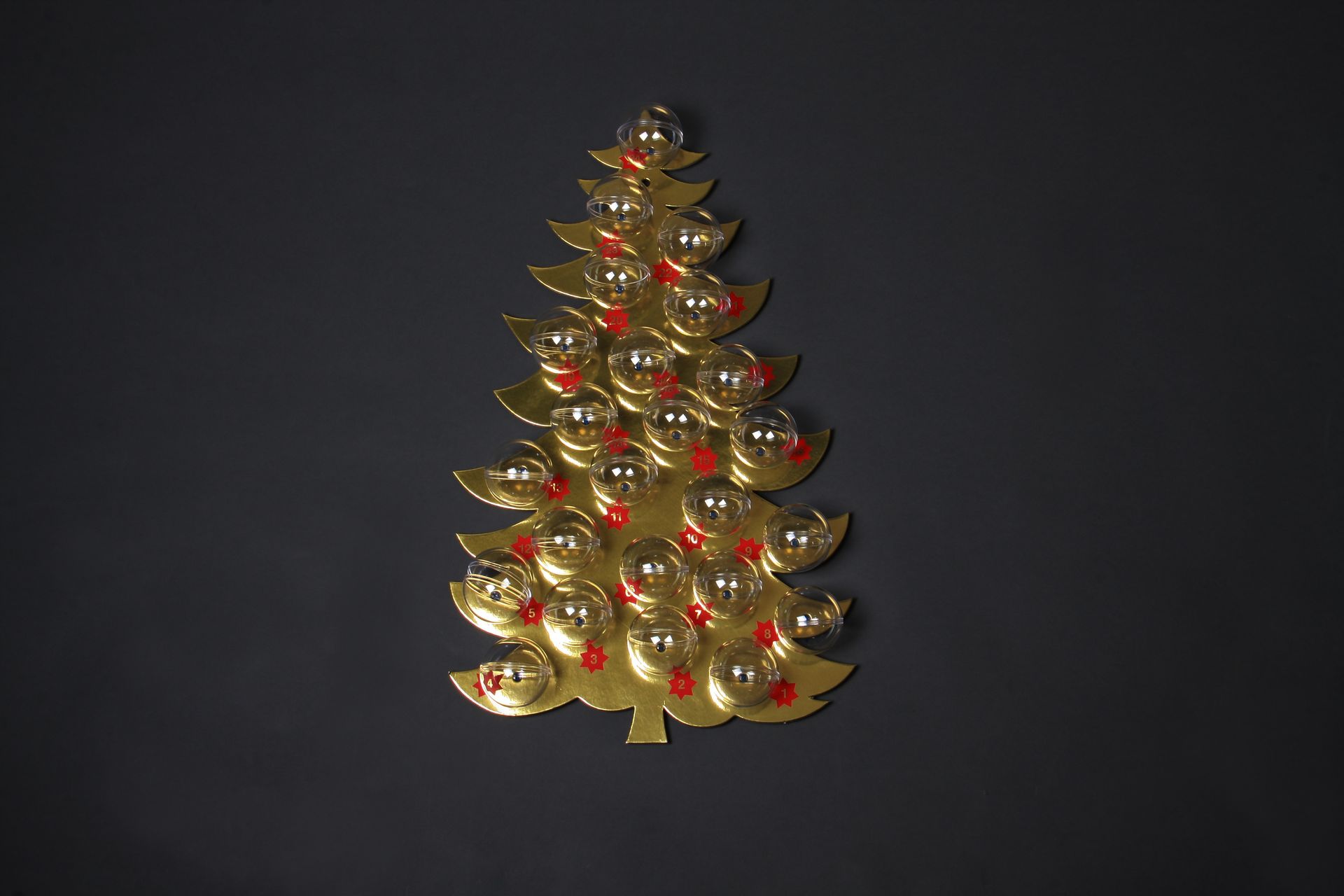 Ein goldener Weihnachtsbaum mit roten Beeren auf schwarzem Hintergrund