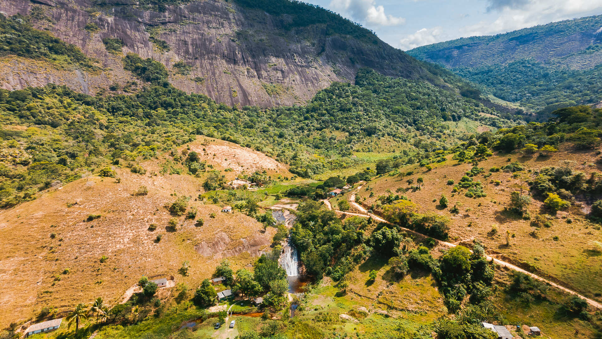 Uma vista aérea de um rio que atravessa um vale verdejante cercado por montanhas.