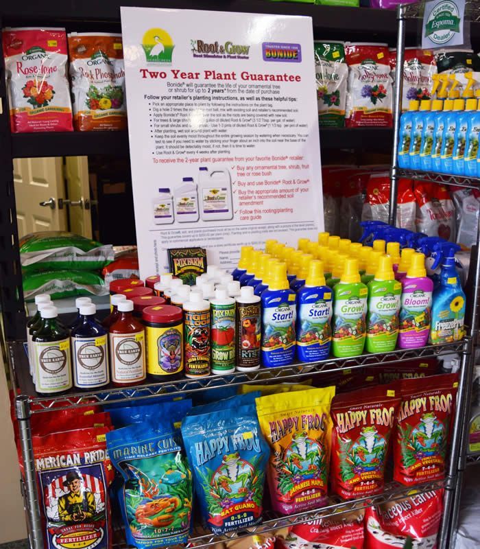 A store shelf displays gardening products like fertilizers, with a 