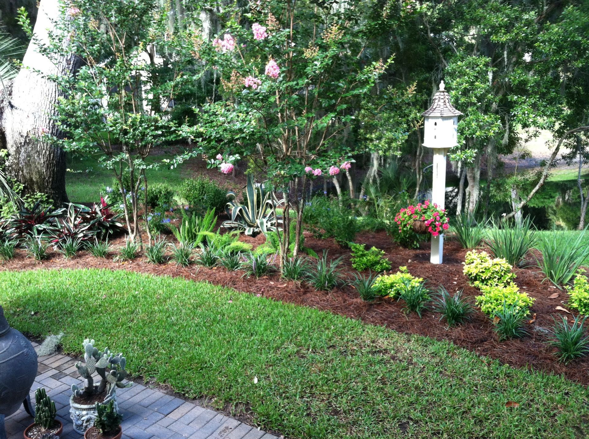 Outdoor seating area decorated with nautical-themed decor, including a fishing net, coral pillows, and a crab statue.