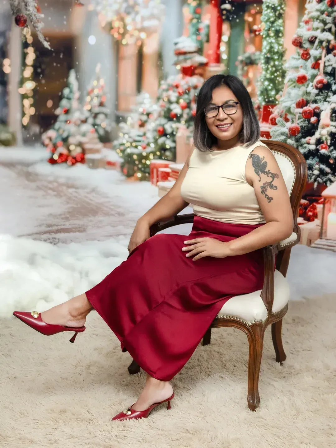 Mujer sentada al aire libre en un ambiente invernal festivo, vestida con una blusa color crema, falda roja y tacones rojos.