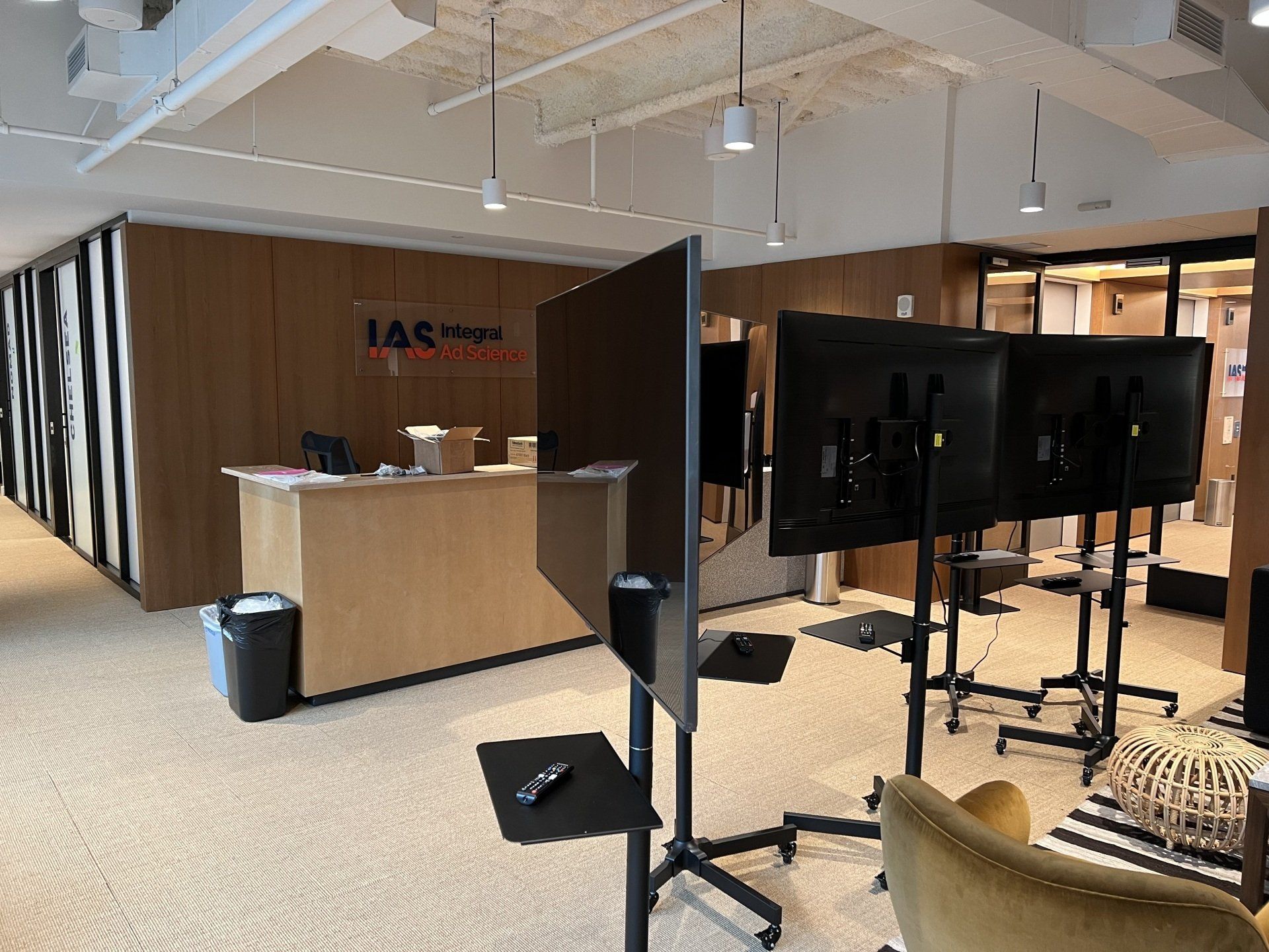 A large room with a reception desk and a lot of televisions on stands