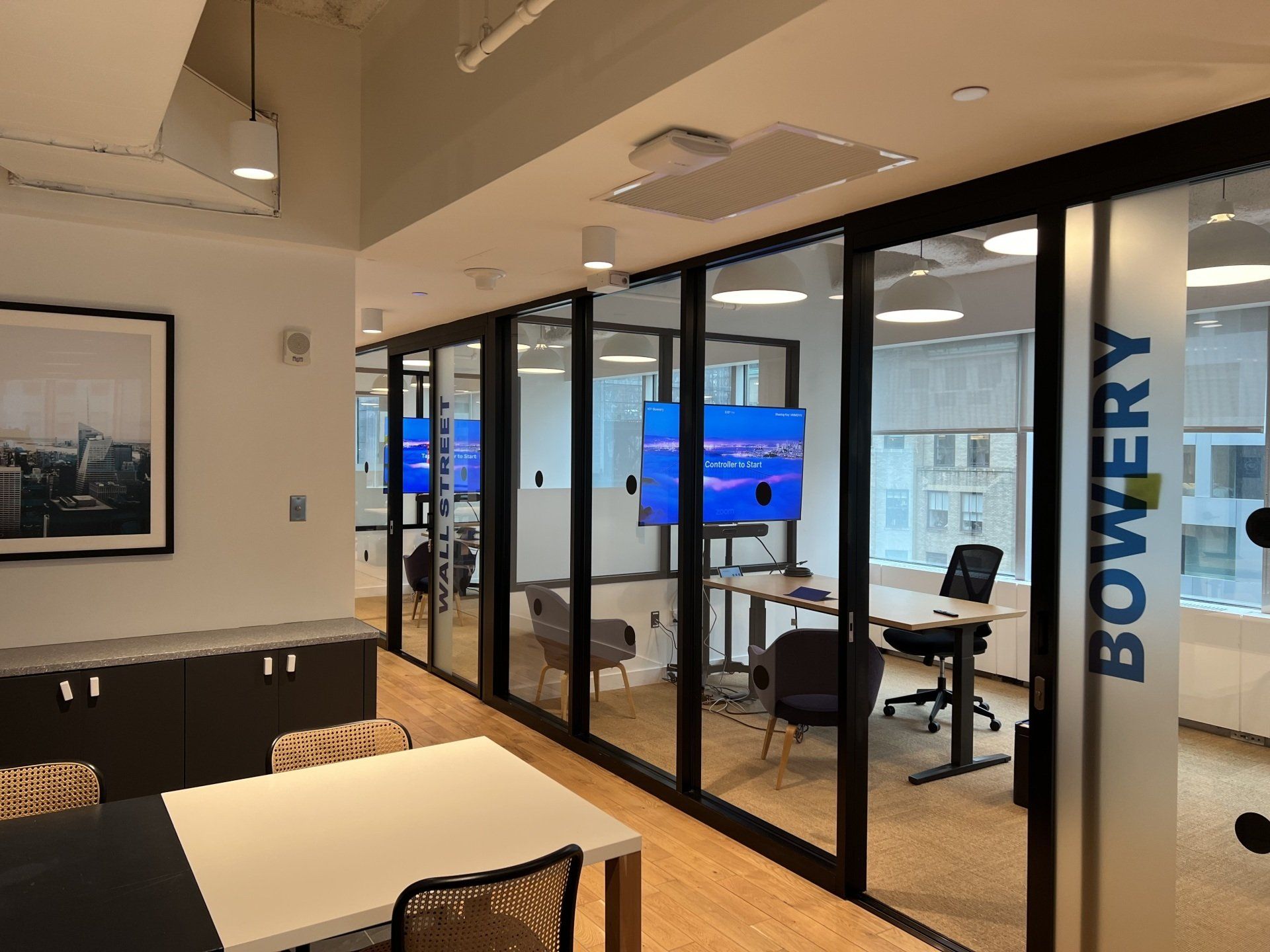 A conference room with a table, chairs, and a television