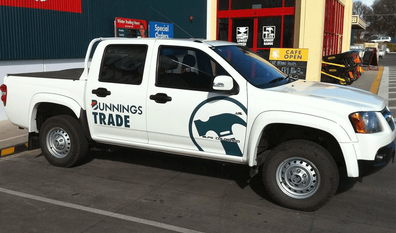 A white truck is parked in front of a building that says bunnings trade — Mountain City Signs In West Tamworth, NSW