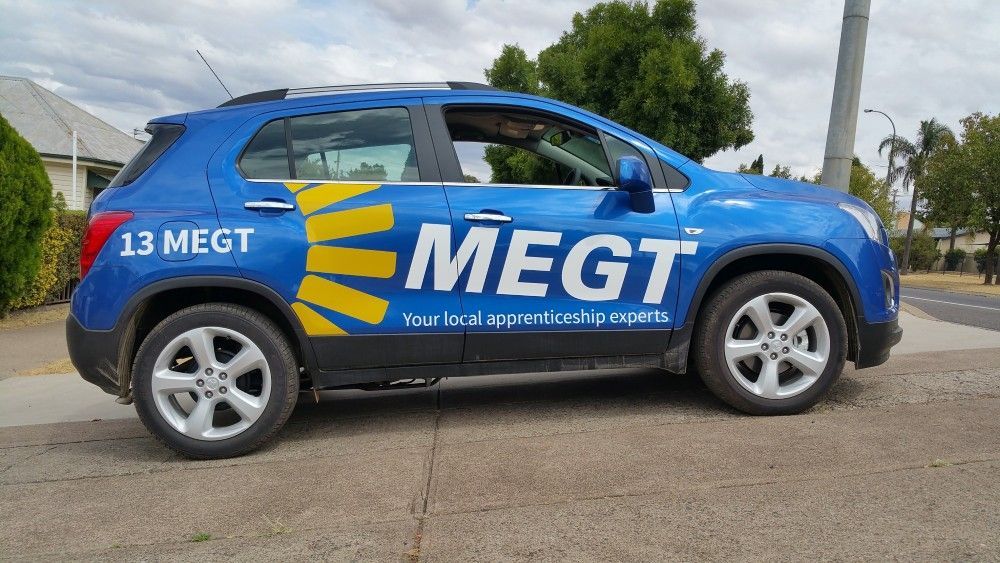 A blue car with the word megt on the side is parked on the side of the road — Mountain City Signs In West Tamworth, NSW