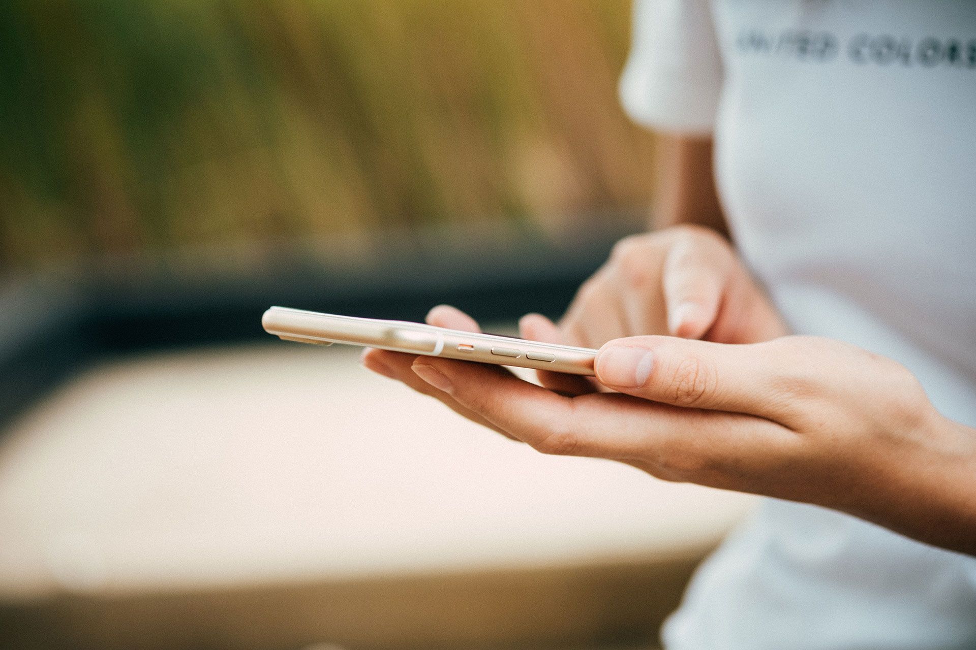A woman is holding a cell phone in her hands.