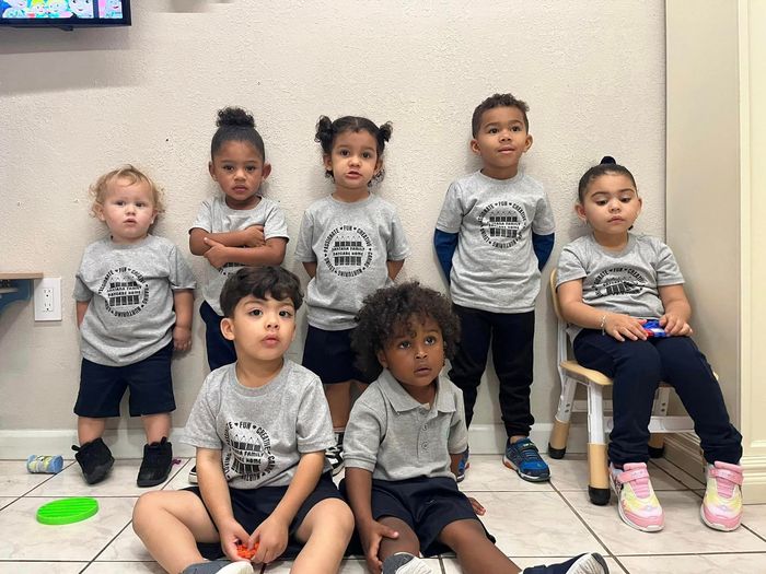 A group of children are sitting on the floor in a room.