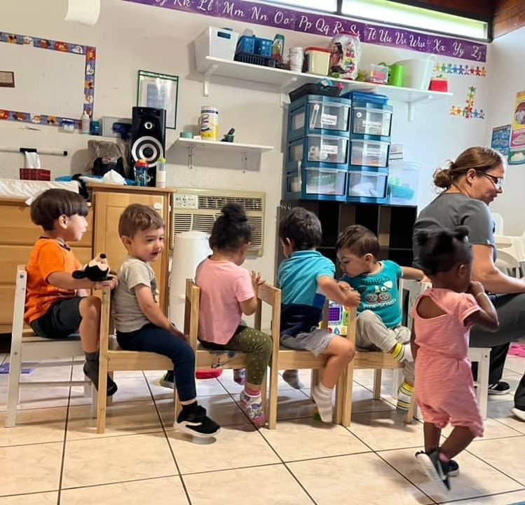 A group of children are sitting in chairs in a classroom