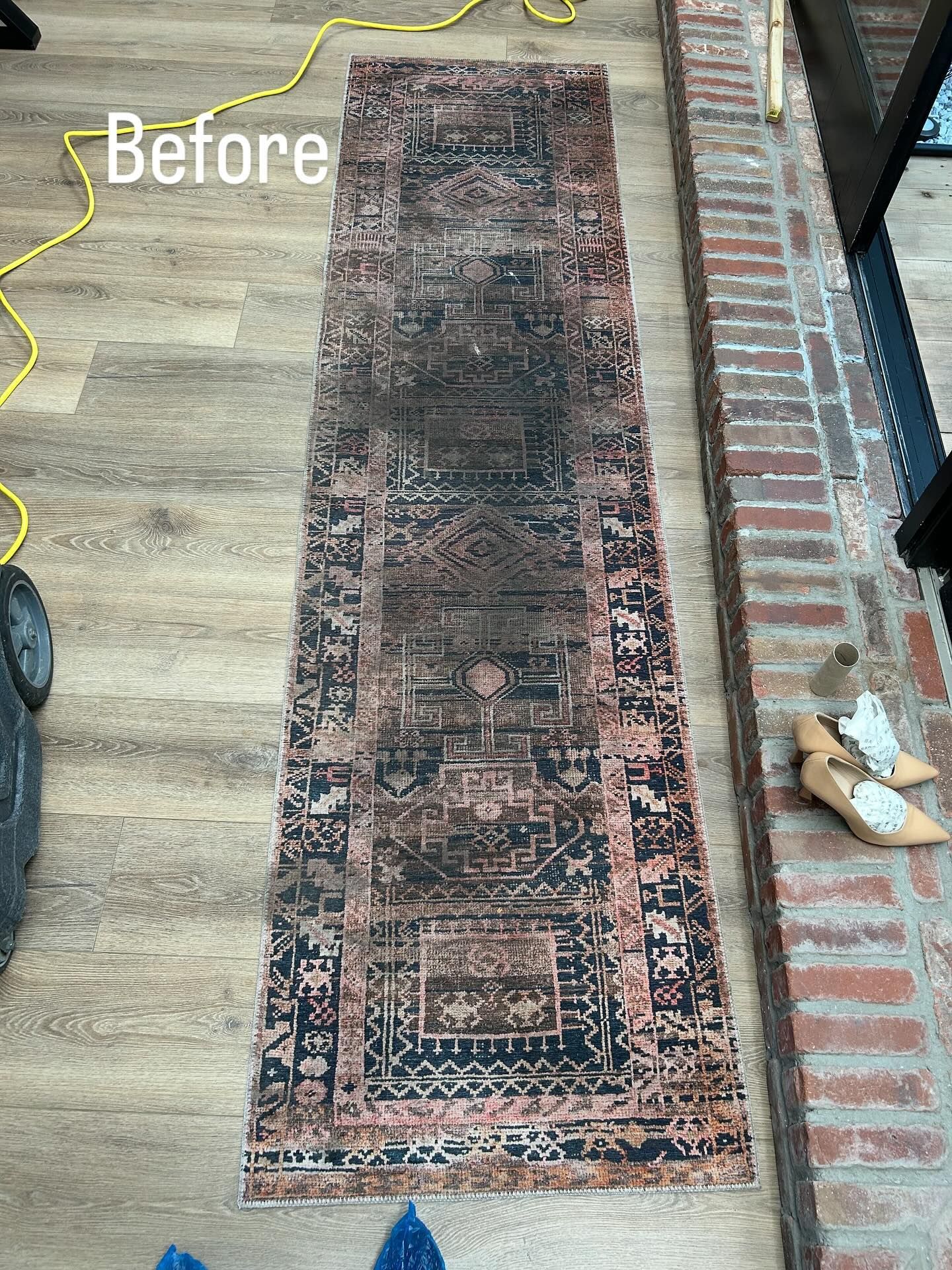 Worn patterned runner rug on wood floor beside a brick threshold, labeled “Before” with a yellow line outline.