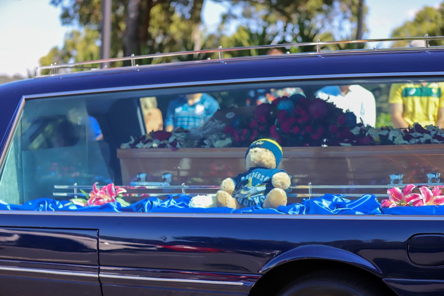 A teddy bear wearing a shirt that says perry - Funeral Services in Upper Coomera, QLD