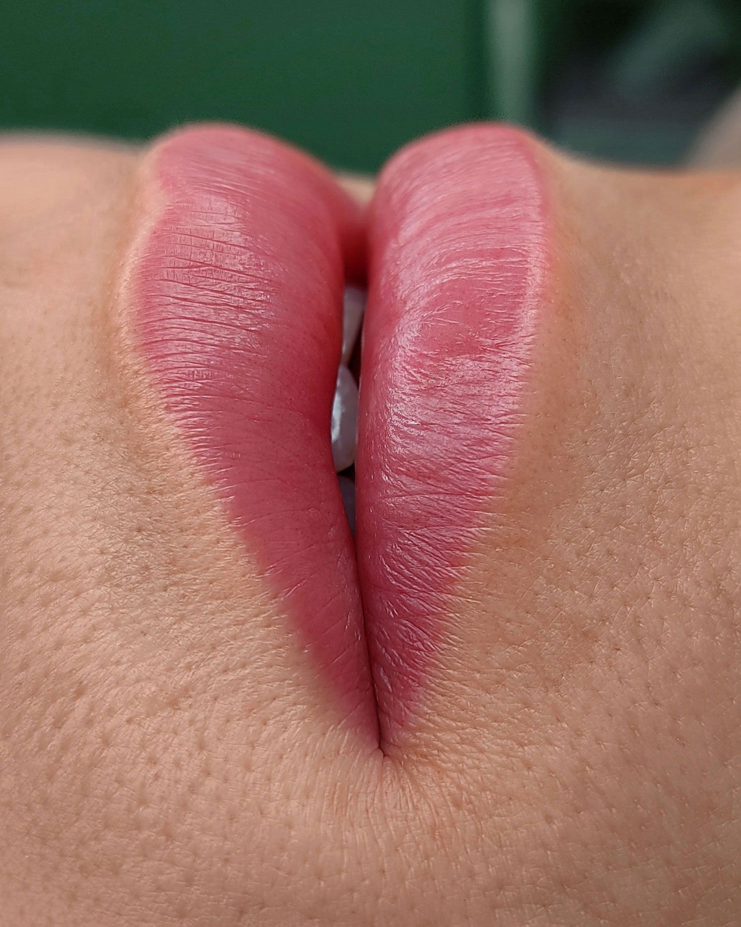 Eine Nahaufnahme der Lippen einer Frau mit rosa Lippenstift.