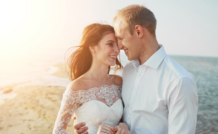 Bride and groom sharing a quiet moment on the beach at sunset
