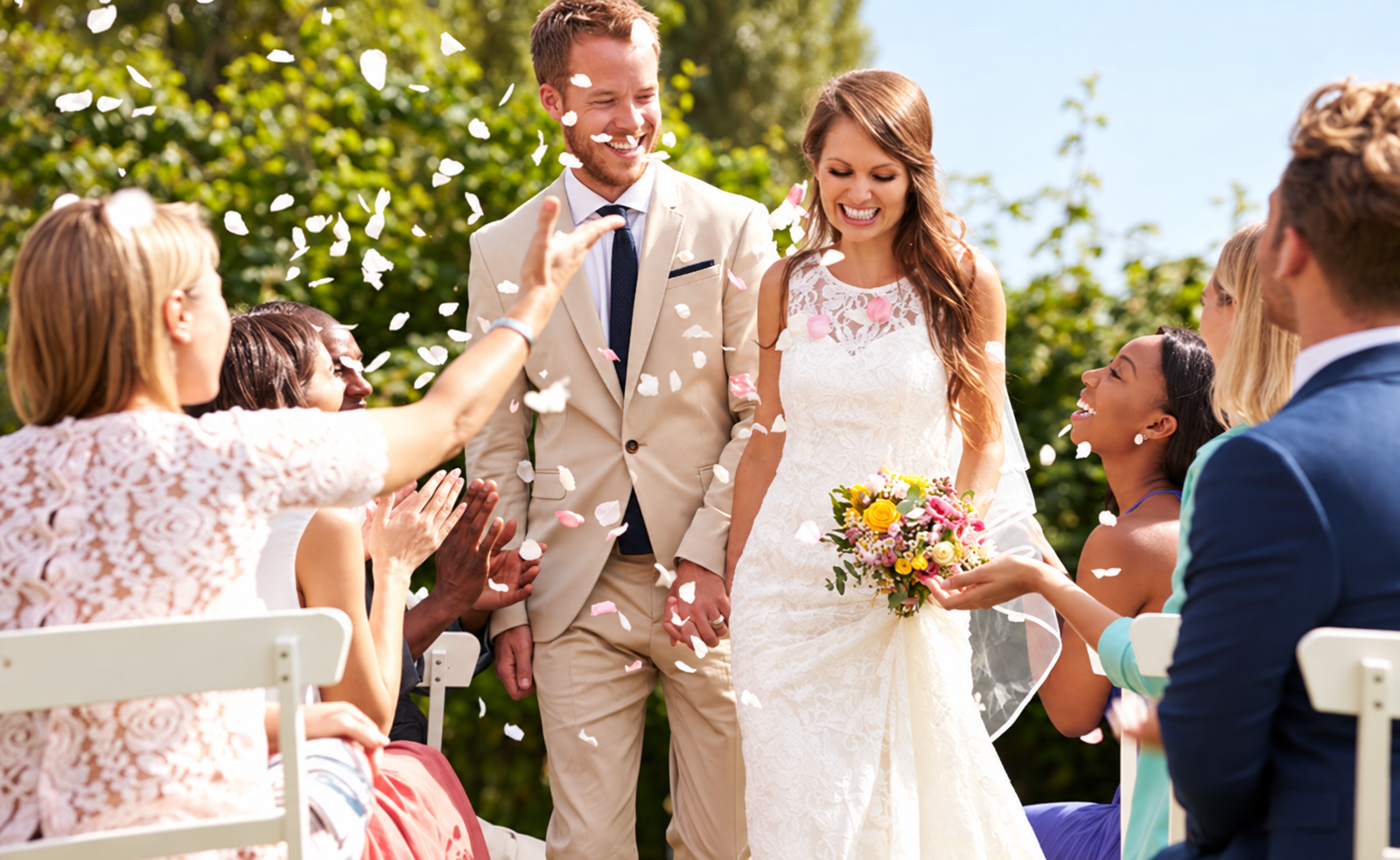 Bride and groom walking back up the aisle as guests congratulate them