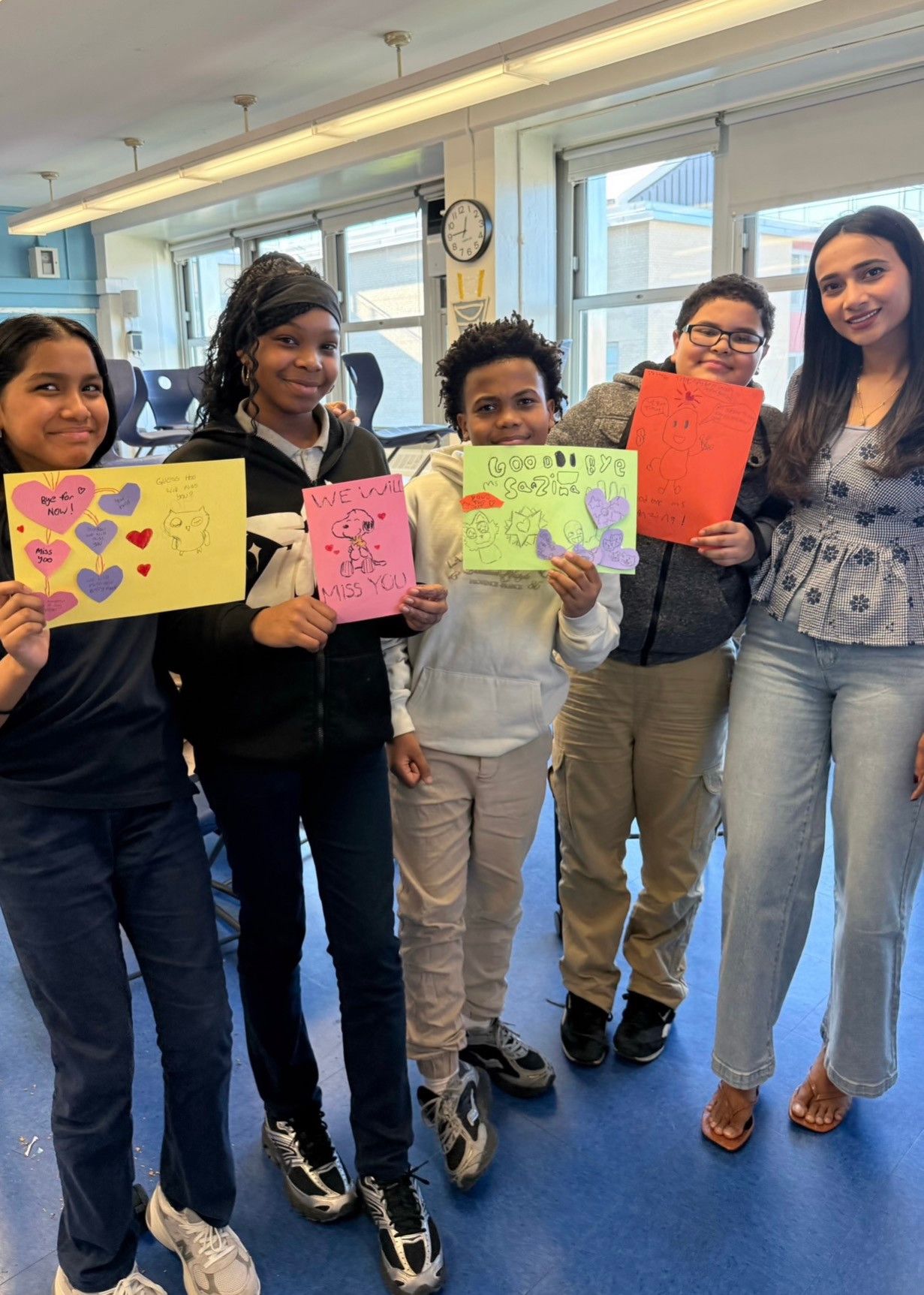 A teacher and students celebrating their time learning together